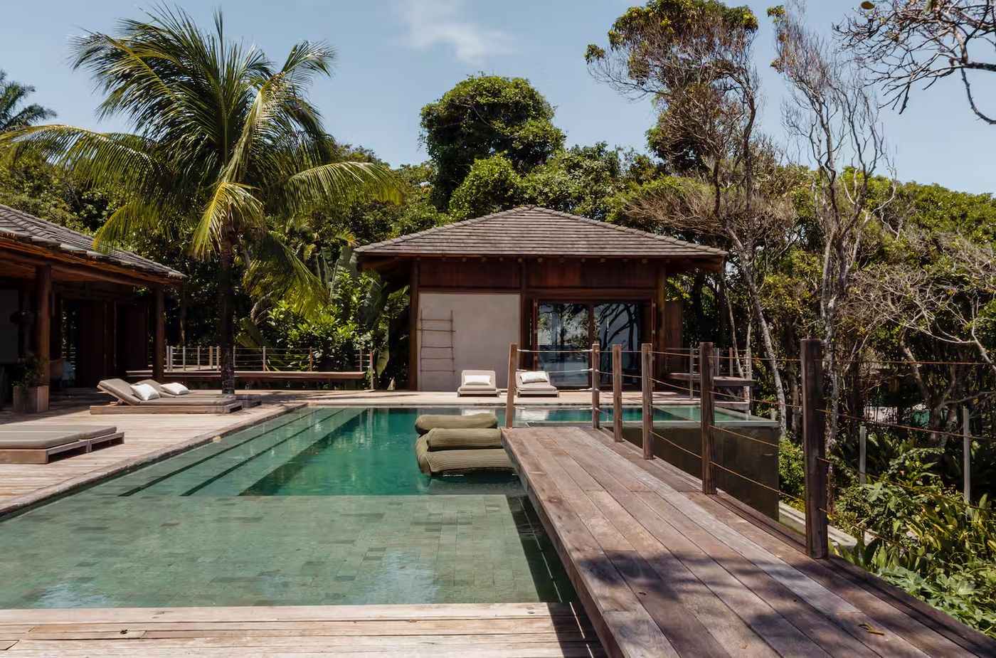 Piscina y bangalô entre palmeras